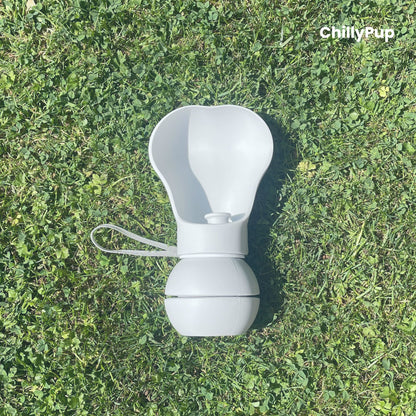 One Foldable silicone water bottle with drinking section on grass.